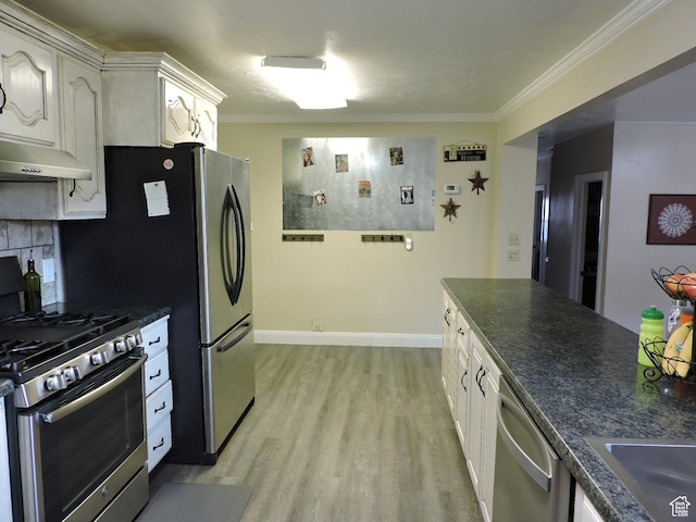 325 N 100 W, Delta, UT 84624 - kitchen featuring light wood-style flooring, dark countertops, crown molding, and appliances with stainless steel finishes