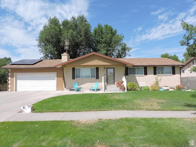 325 N 100 W, Delta, UT 84624 - ranch-style house featuring an attached garage, brick siding, solar panels, and a front yard