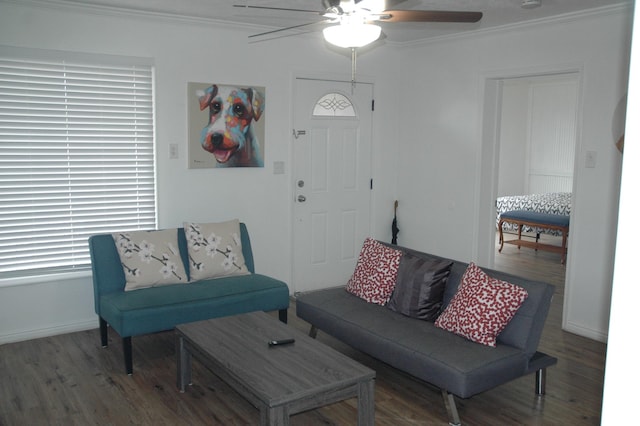 living room with wood finished floors, ornamental molding, baseboards, and a ceiling fan