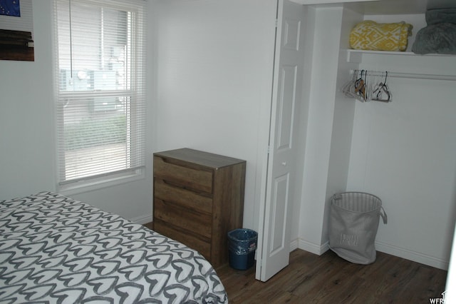 bedroom with dark wood-type flooring and baseboards