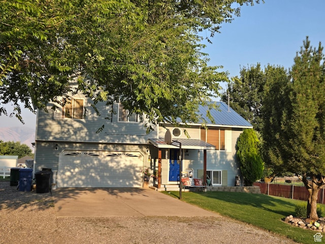 view of front facade featuring concrete driveway, an attached garage, and metal roof