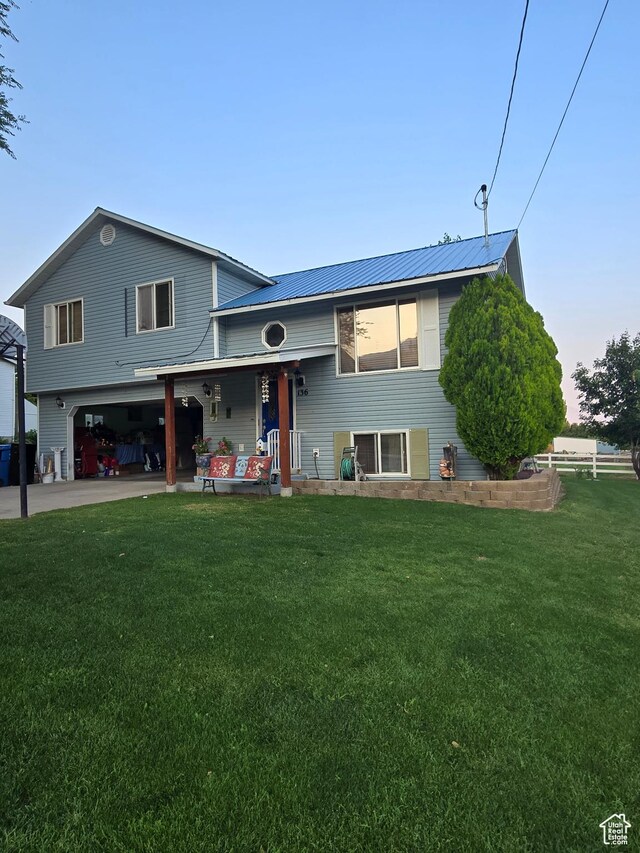 136 S 200 W, Wellsville, UT 84339 - raised ranch featuring a front yard, covered porch, a garage, and metal roof