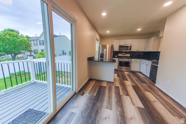 1279 W Culloden Ct, Murray, UT 84123 - kitchen featuring decorative backsplash, dark countertops, dark wood-style floors, stainless steel appliances, and white cabinetry