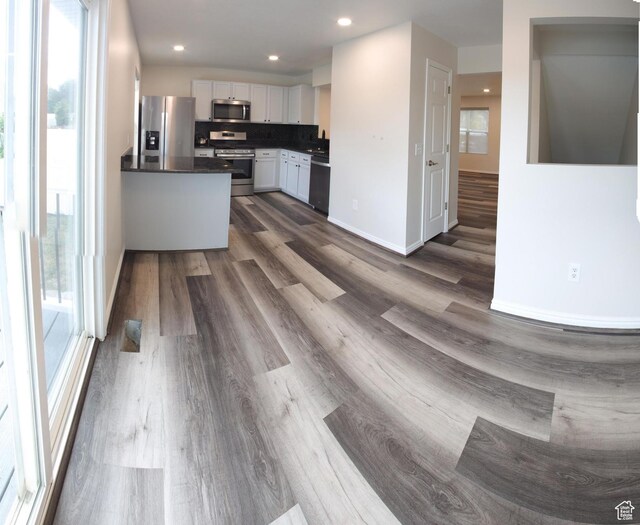 1279 W Culloden Ct, Murray, UT 84123 - kitchen with baseboards, dark countertops, dark wood-type flooring, stainless steel appliances, and white cabinetry