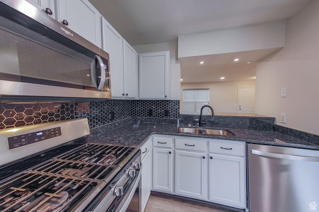 1279 W Culloden Ct, Murray, UT 84123 - kitchen featuring stainless steel appliances, white cabinets, a sink, and backsplash