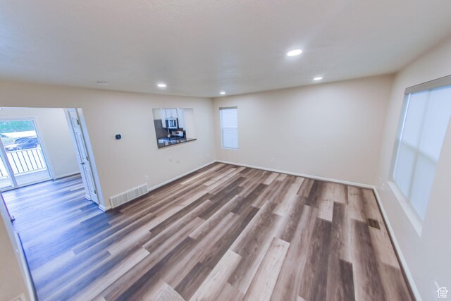 1279 W Culloden Ct, Murray, UT 84123 - empty room featuring recessed lighting, wood finished floors, visible vents, and a healthy amount of sunlight
