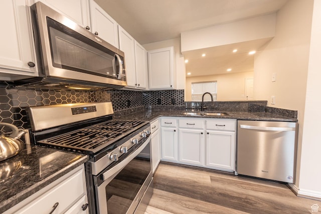1279 W Culloden Ct, Murray, UT 84123 - kitchen featuring light wood finished floors, tasteful backsplash, appliances with stainless steel finishes, white cabinetry, and a sink