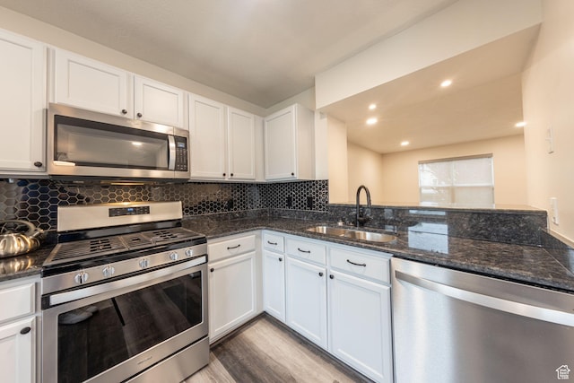 1279 W Culloden Ct, Murray, UT 84123 - kitchen with white cabinets, decorative backsplash, stainless steel appliances, and a sink