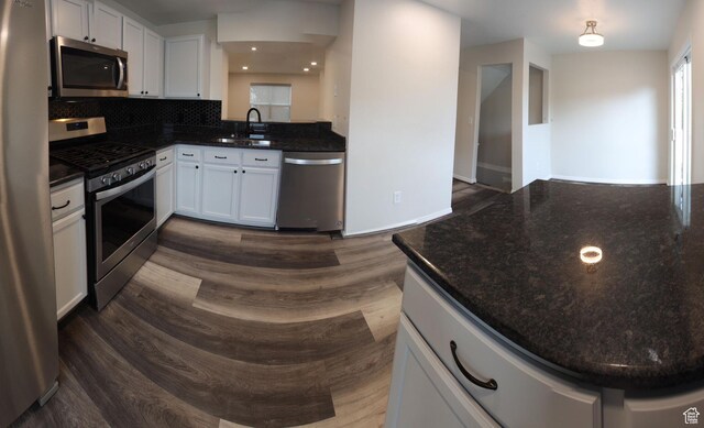 1279 W Culloden Ct, Murray, UT 84123 - kitchen with decorative backsplash, dark stone counters, dark wood-style flooring, stainless steel appliances, and a sink