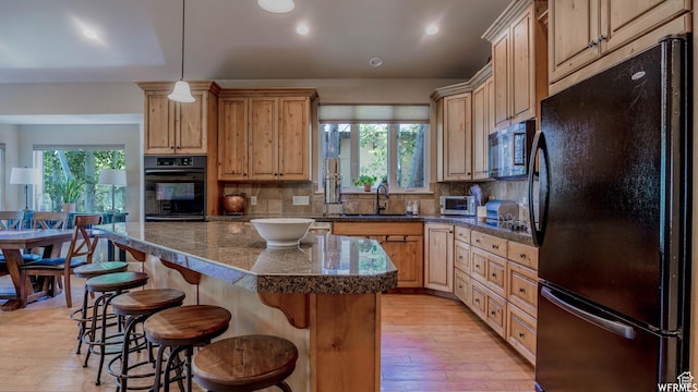 1336 Antibe Ln, Midway, UT 84049 - kitchen featuring a kitchen bar, sink, light brown cabinets, a kitchen island, and black appliances