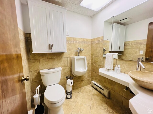 588 W Raspberry Patch Rd, Garden City, UT 84028 - half bathroom featuring a baseboard radiator, toilet, tile patterned floors, a paneled ceiling, and a sink