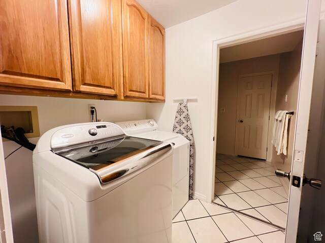 588 W Raspberry Patch Rd, Garden City, UT 84028 - laundry area featuring light tile patterned floors, cabinet space, and washer and clothes dryer