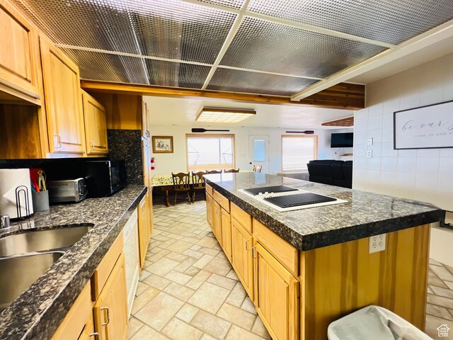 588 W Raspberry Patch Rd, Garden City, UT 84028 - kitchen featuring dark countertops, tasteful backsplash, a kitchen island, stone tile flooring, and tile walls