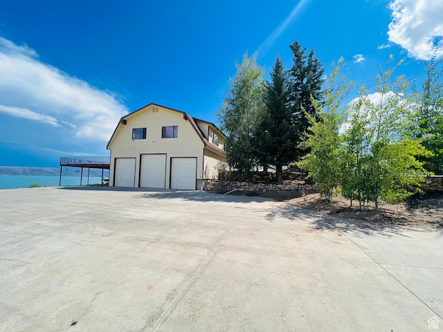 588 W Raspberry Patch Rd, Garden City, UT 84028 - view of side of home with a garage, a gambrel roof, and concrete driveway