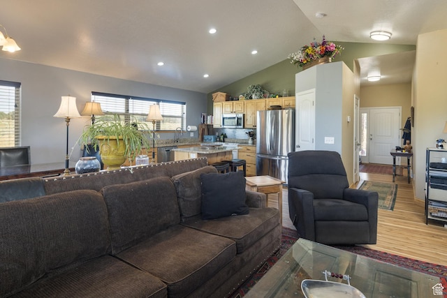 living area with lofted ceiling, recessed lighting, and wood finished floors