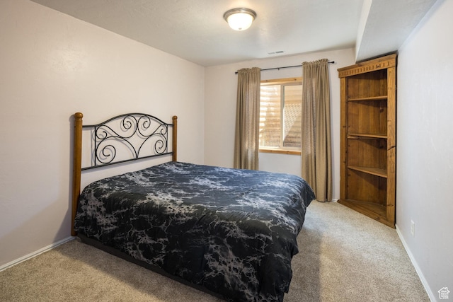 carpeted bedroom featuring visible vents and baseboards