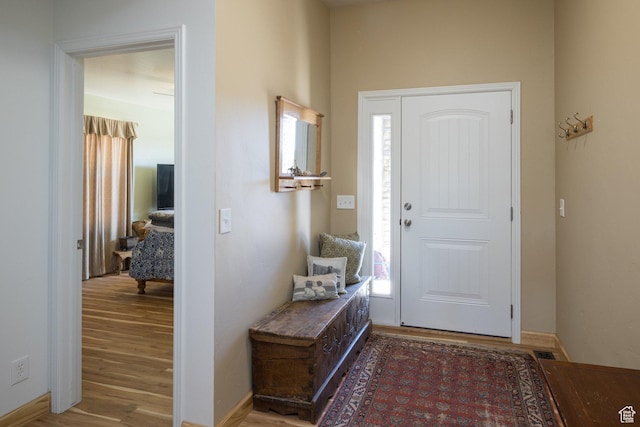 entryway with plenty of natural light, baseboards, and wood finished floors