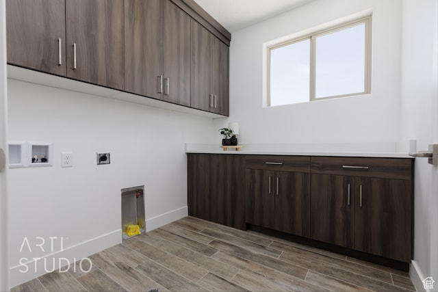 laundry area featuring cabinets, wood-type flooring, electric dryer hookup, and washer hookup