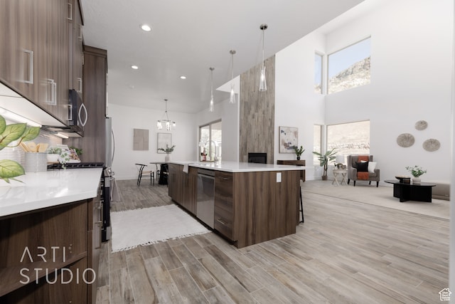 kitchen with pendant lighting, dark brown cabinetry, and appliances with stainless steel finishes