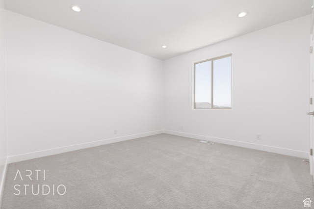 spare room featuring light colored carpet