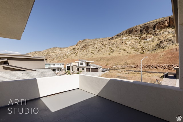 view of patio with a balcony and a mountain view