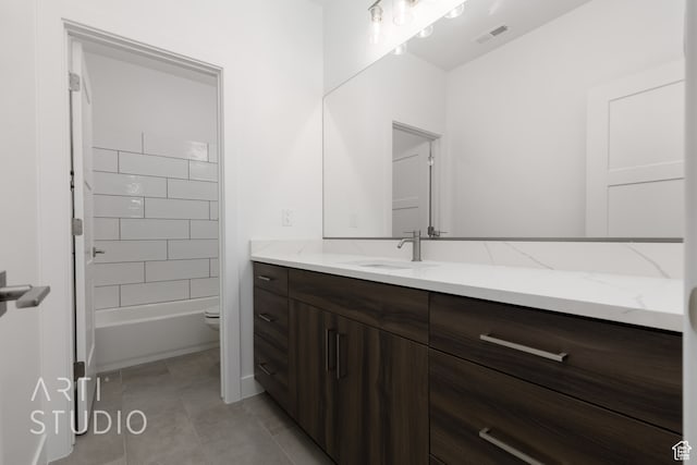 full bathroom with vanity, tiled shower / bath, tile patterned floors, and toilet