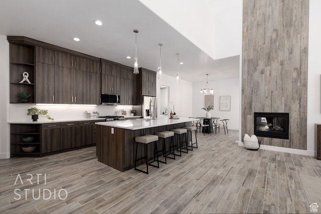 kitchen featuring appliances with stainless steel finishes, pendant lighting, and dark brown cabinetry