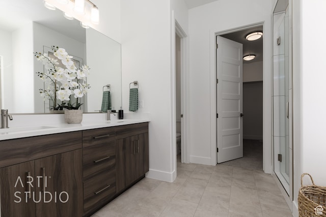 bathroom featuring vanity, tile patterned flooring, a shower with door, and toilet
