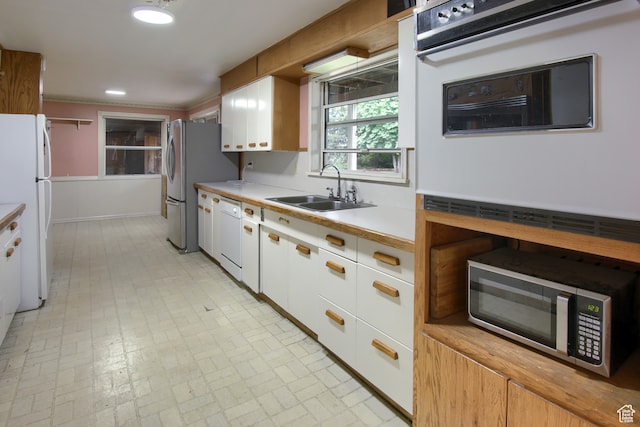 kitchen with white appliances, sink, white cabinets, and light tile patterned floors