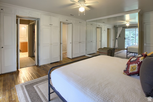 bedroom with ensuite bath, wood-type flooring, ornamental molding, and ceiling fan