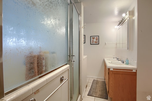 bathroom featuring tile patterned floors, double vanity, and walk in shower