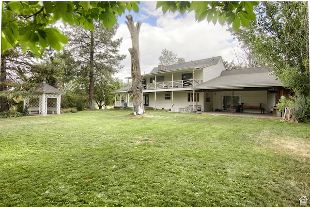 rear view of property with a yard and a patio area