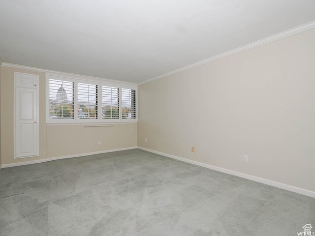 carpeted empty room with baseboards and crown molding
