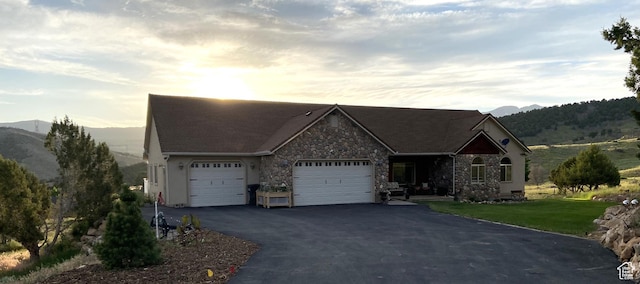 19638 S Buckskin Cir, Birdseye, UT 84629 - ranch-style house featuring a front lawn, aphalt driveway, a garage, stone siding, and a mountain view