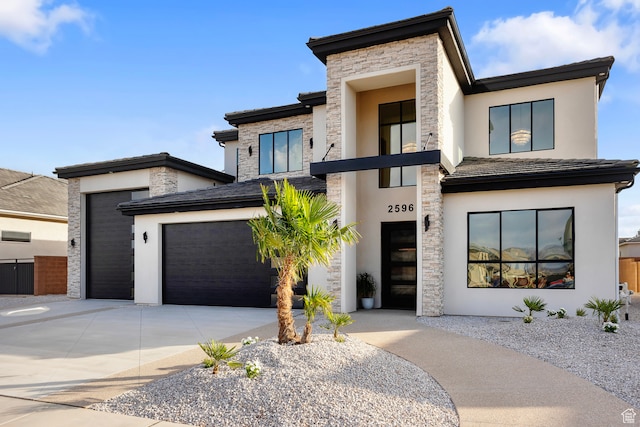 2596 S Gritton St, Hurricane, UT 84737 - view of front of house with stucco siding, stone siding, a garage, and concrete driveway