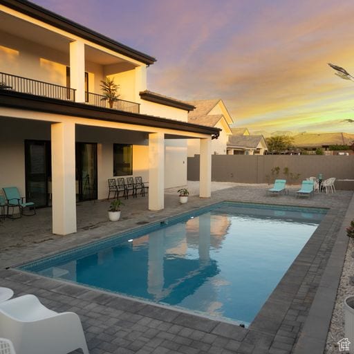 2596 S Gritton St, Hurricane, UT 84737 - pool at dusk with a fenced in pool, a patio, and fence