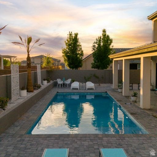 2596 S Gritton St, Hurricane, UT 84737 - pool at dusk featuring a fenced in pool, a patio, and a fenced backyard