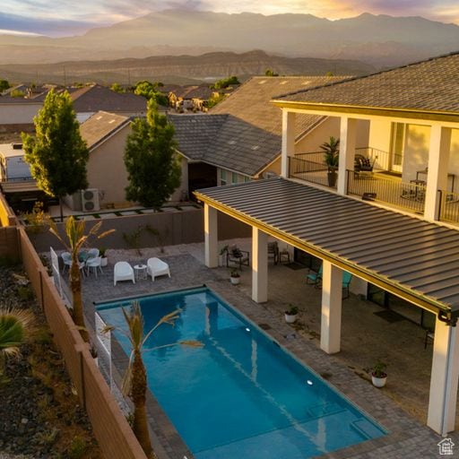 2596 S Gritton St, Hurricane, UT 84737 - pool at dusk with a mountain view, fence, a fenced in pool, and a patio area