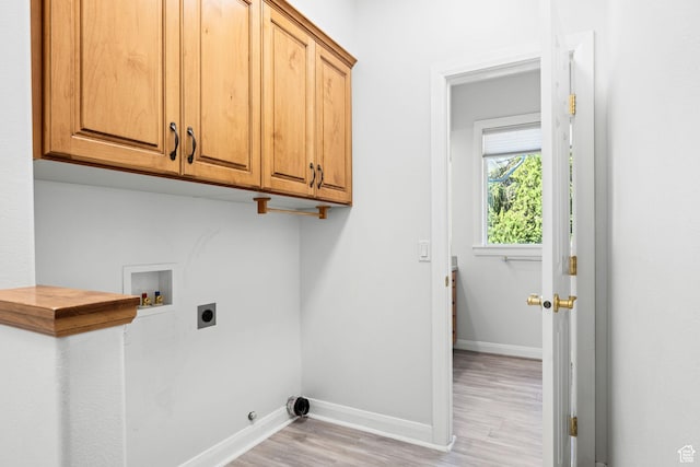 laundry room featuring cabinet space, baseboards, hookup for an electric dryer, light wood-type flooring, and washer hookup