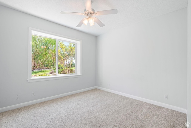 carpeted spare room with ceiling fan, a textured ceiling, and baseboards