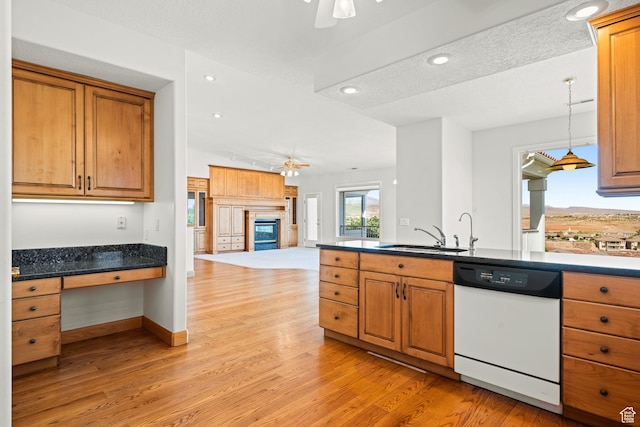 kitchen featuring built in desk, light wood-style flooring, open floor plan, a sink, and dishwasher