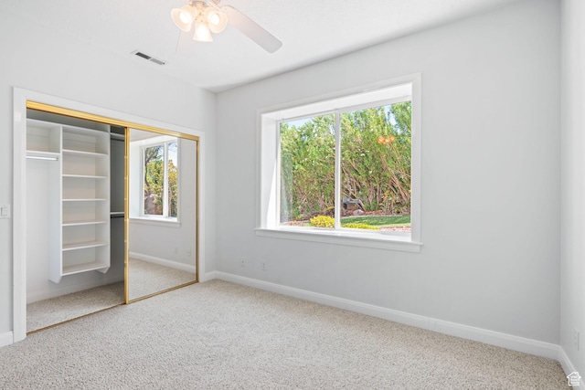 unfurnished bedroom with carpet floors, a closet, visible vents, and baseboards