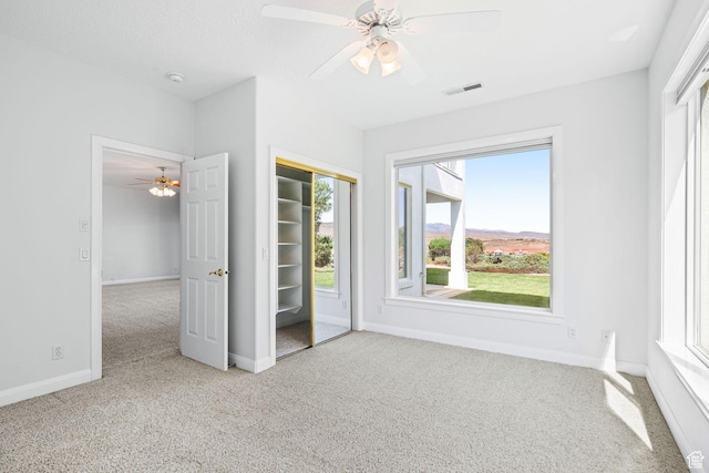 unfurnished bedroom featuring baseboards, visible vents, ceiling fan, a textured ceiling, and carpet floors
