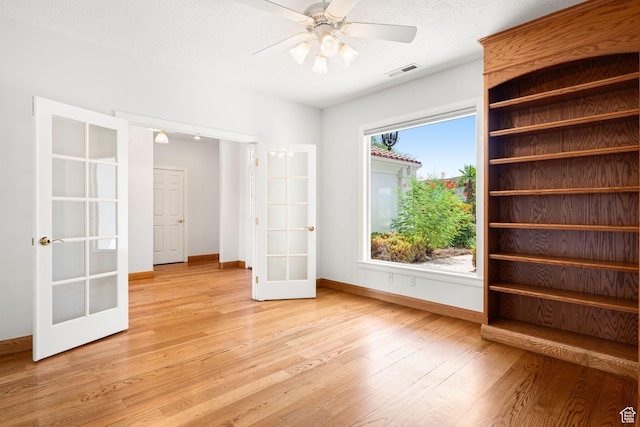 unfurnished room featuring light wood finished floors, french doors, visible vents, and baseboards