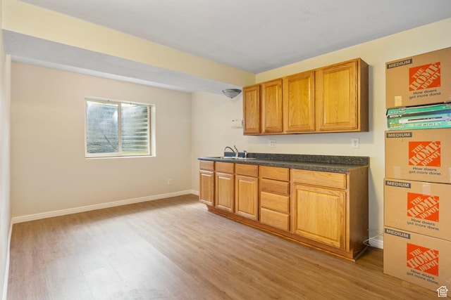 546 E River Meadow Dr S, Alpine, UT 84004 - kitchen with baseboards, light wood-type flooring, dark countertops, brown cabinetry, and a sink