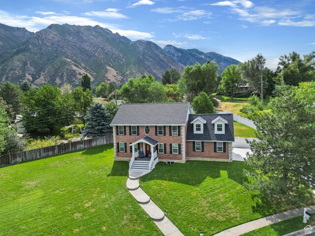546 E River Meadow Dr S, Alpine, UT 84004 - view of front of house featuring brick siding, a mountain view, fence, and a front yard