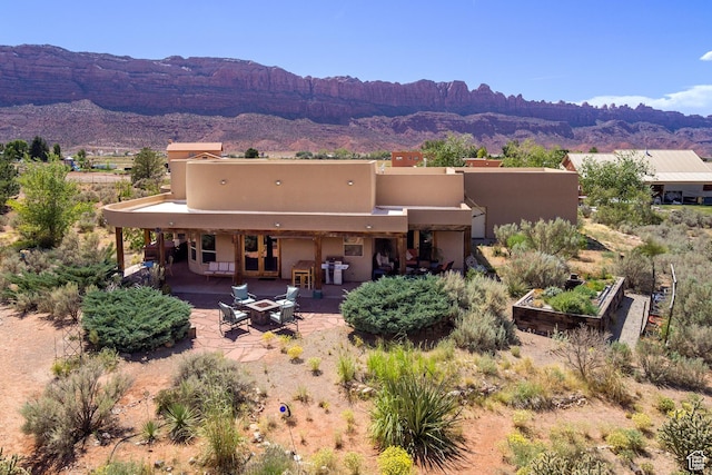 431 E Coronado Ln, Moab, UT 84532 - back of house with stucco siding, a mountain view, a patio, and a garden