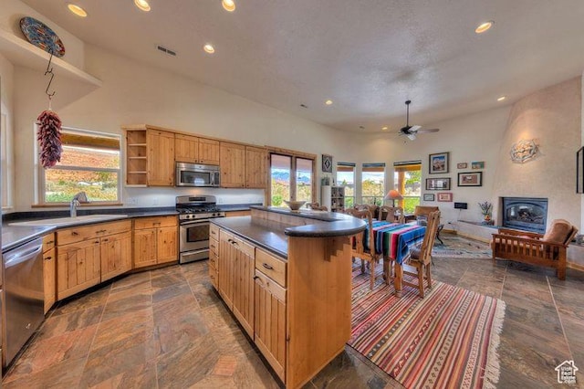 431 E Coronado Ln, Moab, UT 84532 - kitchen with dark countertops, open shelves, appliances with stainless steel finishes, stone tile flooring, and a sink