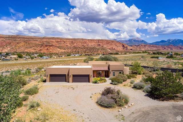 431 E Coronado Ln, Moab, UT 84532 - view of front facade featuring a garage, a mountain view, driveway, and stucco siding