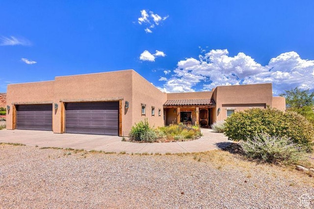 431 E Coronado Ln, Moab, UT 84532 - pueblo revival-style home featuring stucco siding, an attached garage, and driveway